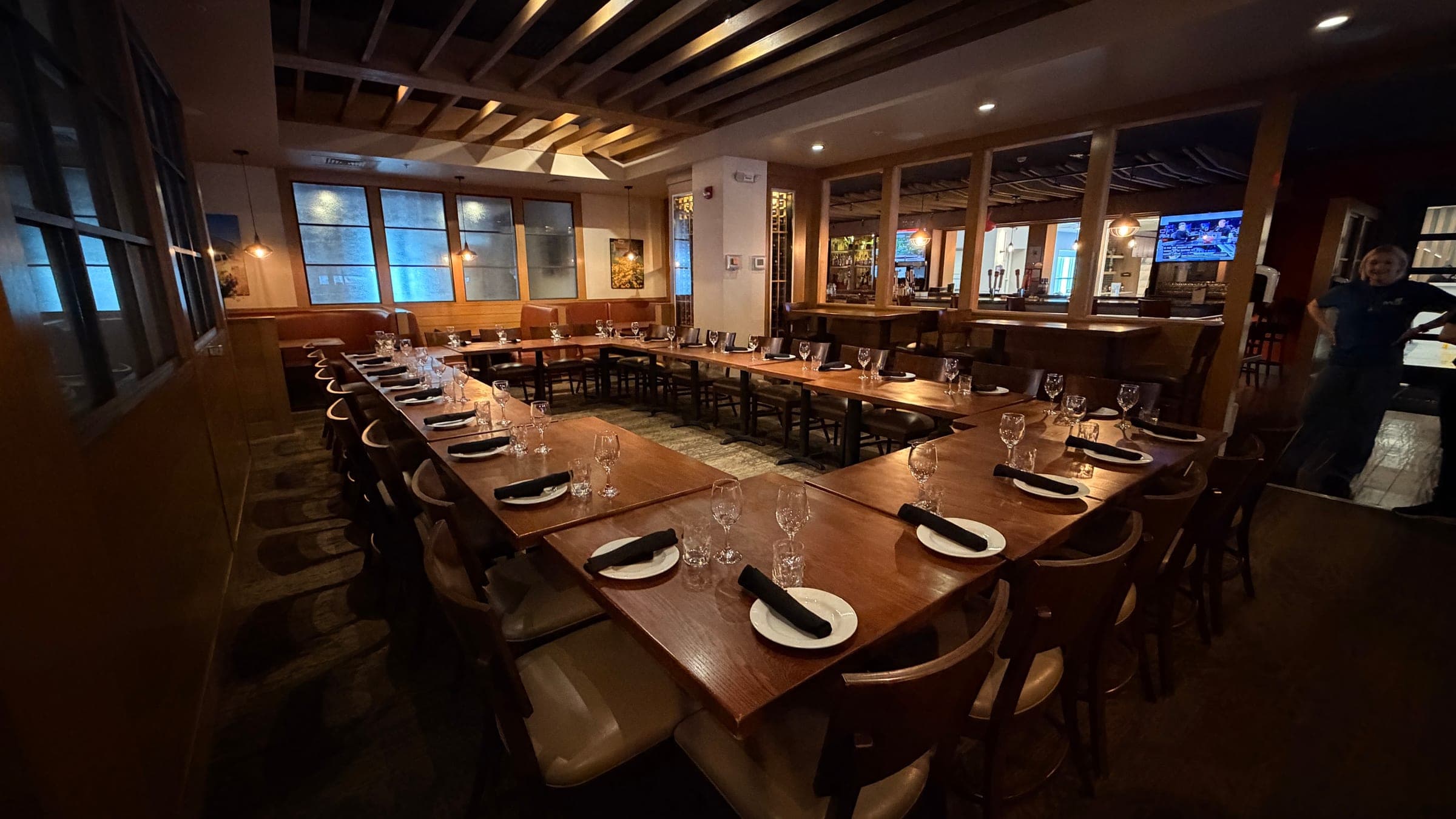 Semi-private dining area at Redz with a U-shaped table setup and glass walls toward the bar