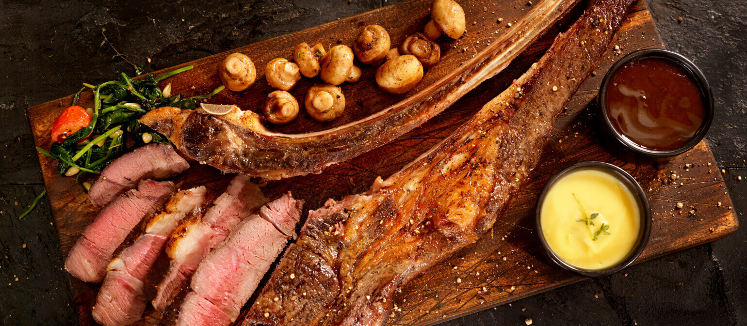 Giant bone-in tomahawk steak with mushrooms